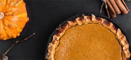 Pumpkin pie and gourds on a black table