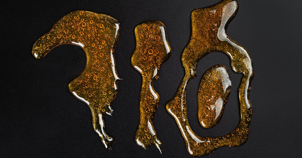 "710" spelled out in cannabis oil on a black background